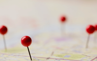 Close-up of red pushpins marking locations on a U.S. map, representing regional foreclosure activity across different housing markets in 2025.