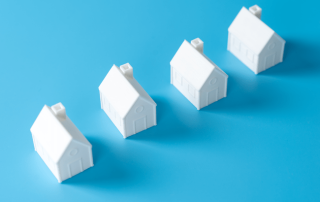 Row of small white houses representing rising foreclosure risk in the Jacksonville, FL housing market